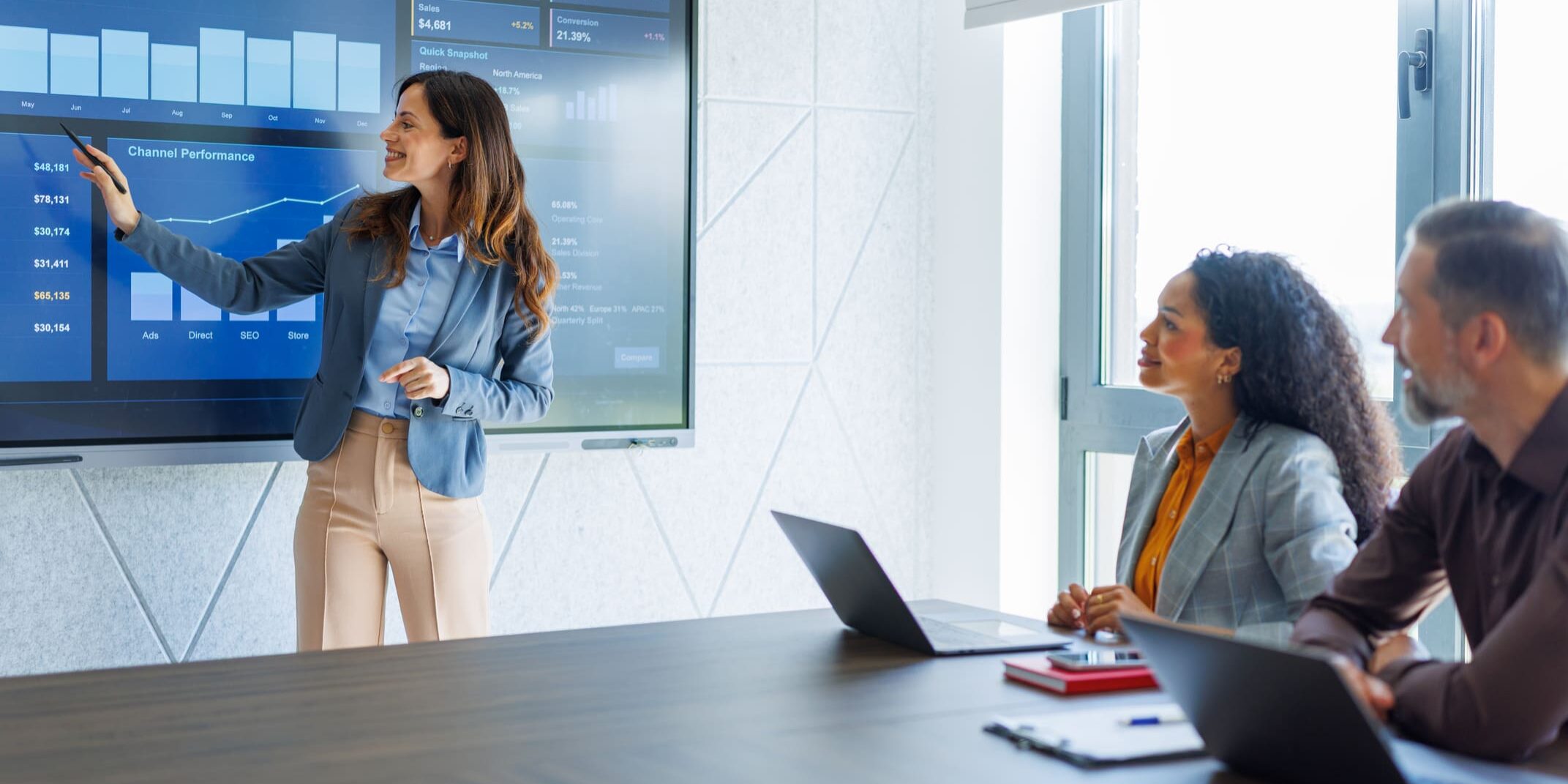 Woman presenting data to colleagues in meeting.